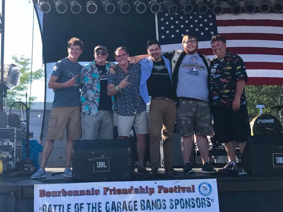 Andrew and a band onstage at a community festival